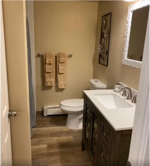 A bathroom with a toilet a sink and a mirror