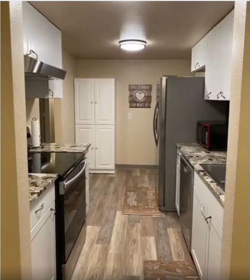 A kitchen with stainless steel appliances and white cabinets