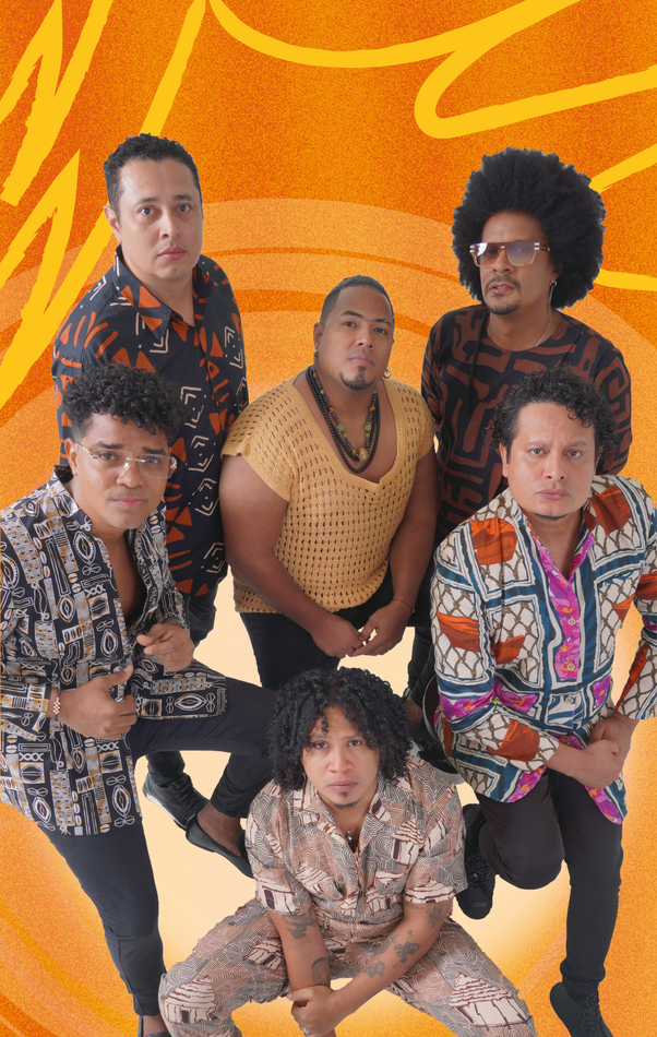 Seis personas con camisas estampadas posan para una foto sobre un fondo naranja.