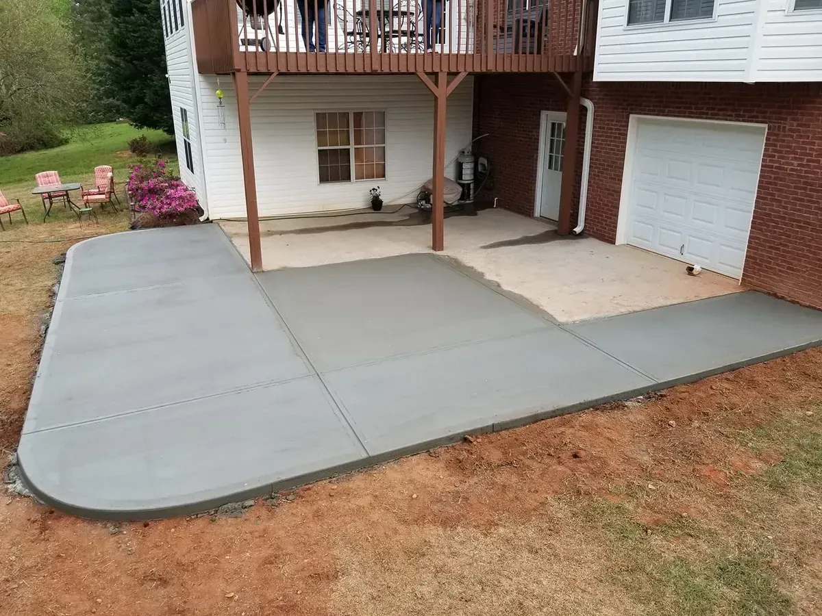 A concrete patio is being built in front of a house.