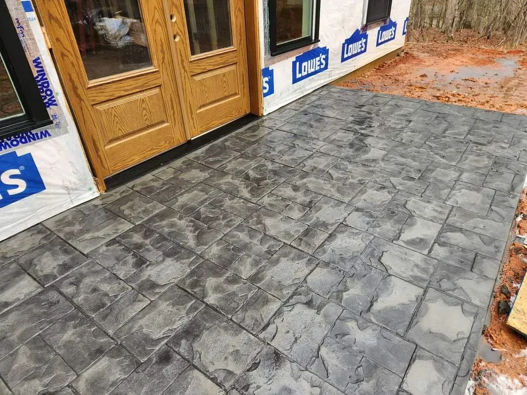 A concrete patio is being built in front of a house.