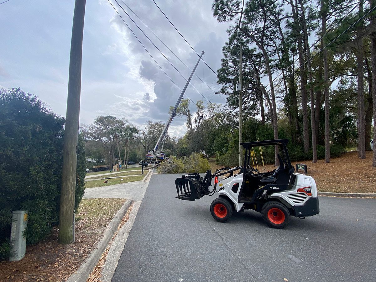 A forklift is driving down a street next to a power line.
