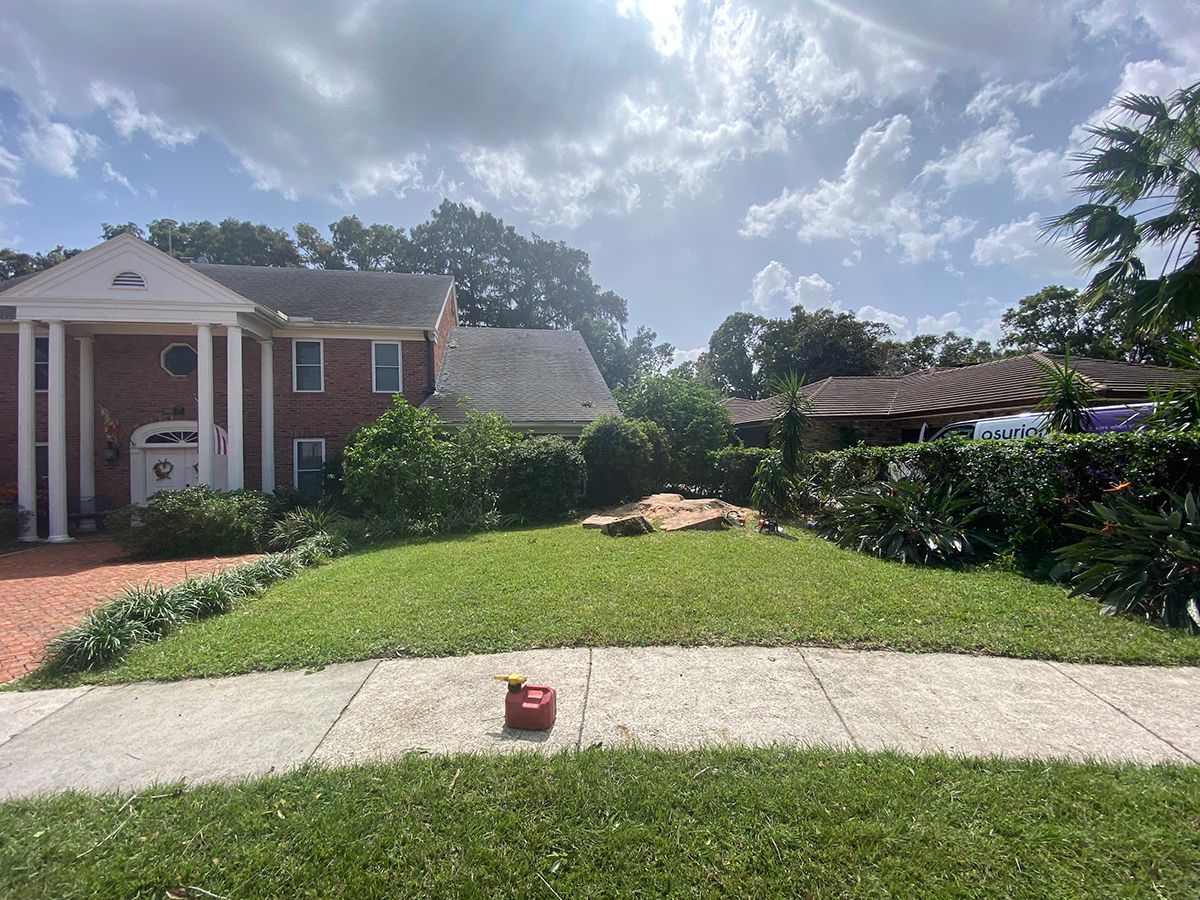 A large brick house with a lush green lawn in front of it.
