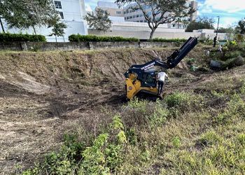 A bulldozer is sitting in the middle of a field.
