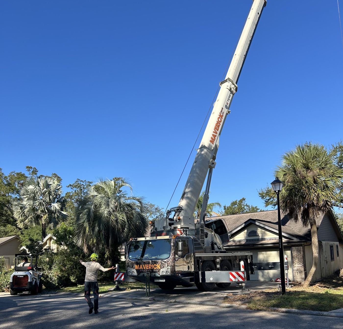 A man stands in front of a large crane that says ' simpson ' on it