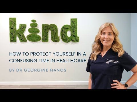 Dr. Georgine Nanos in scrubs stands by a wall with the word 