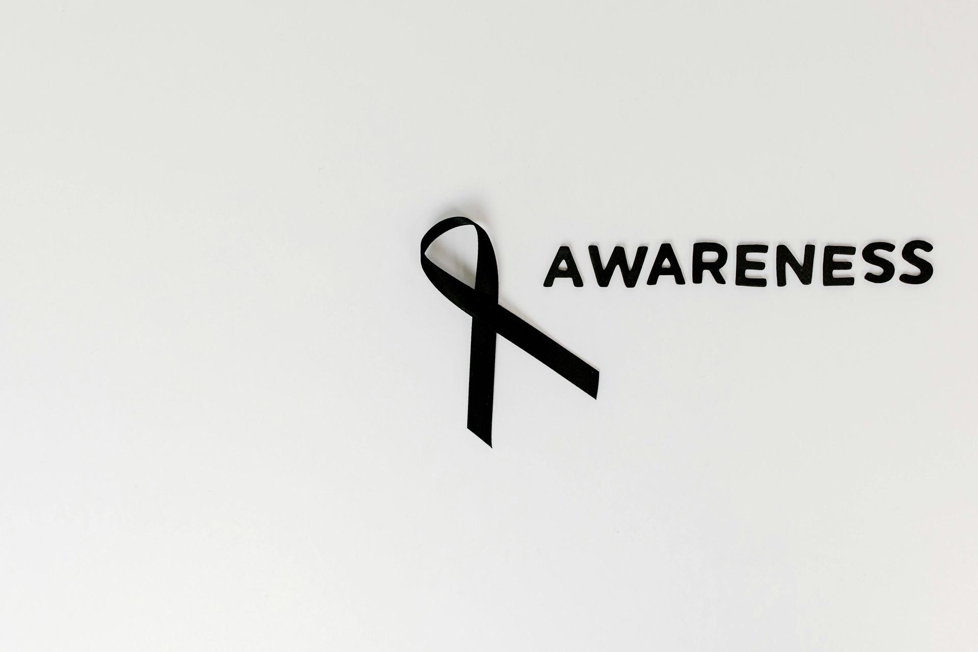 Awareness ribbon with the word “AWARENESS” on a white background