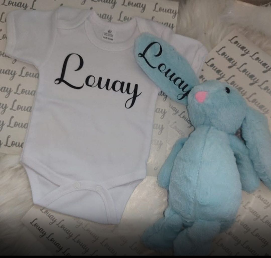 Wit babyrompertje en blauw konijnenknuffelpakje, beide met de opdruk 