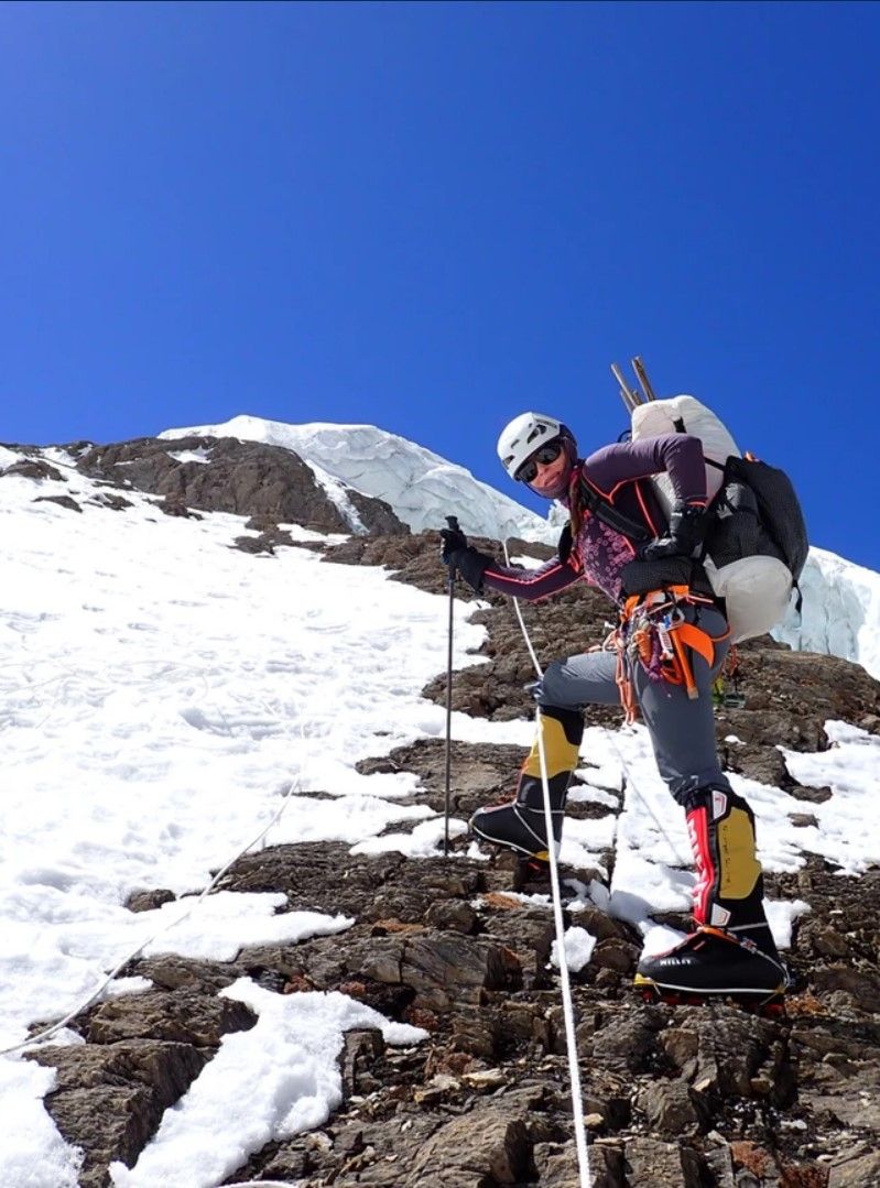 Alessandra Pepper is climbing a snowy mountain with a backpack.