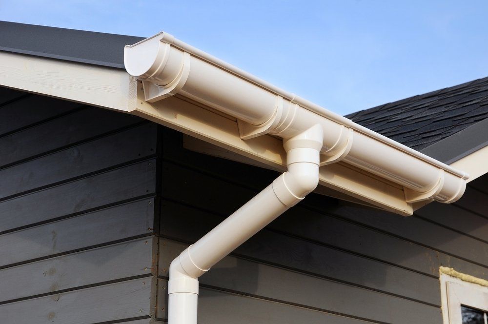 A White Gutter on the Side of a House With a Black Roof — Greg Mitchell Plumbing In Murgon, QLD