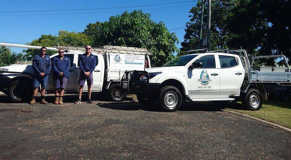 Plumbers Standing Beside Company Vehicle