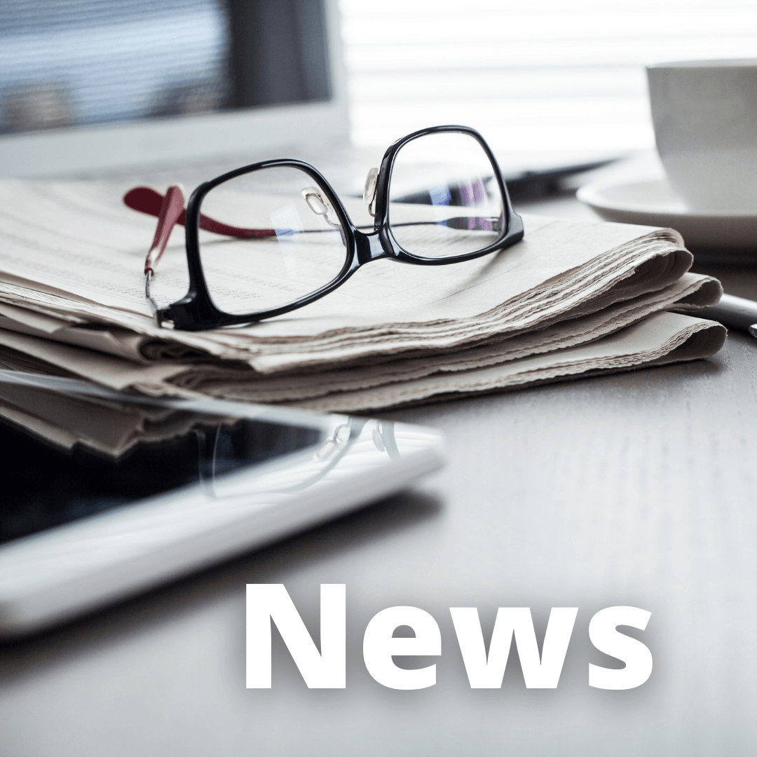 Um par de óculos em cima de uma pilha de jornais