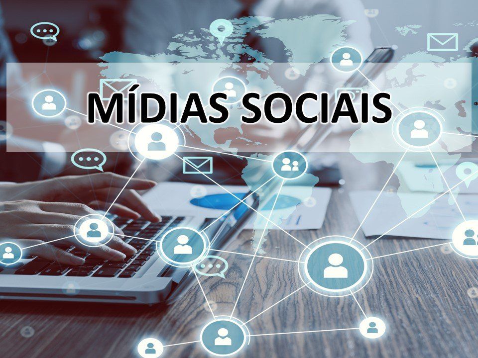 Uma pessoa está digitando em um laptop com as palavras medias sociais ao fundo.