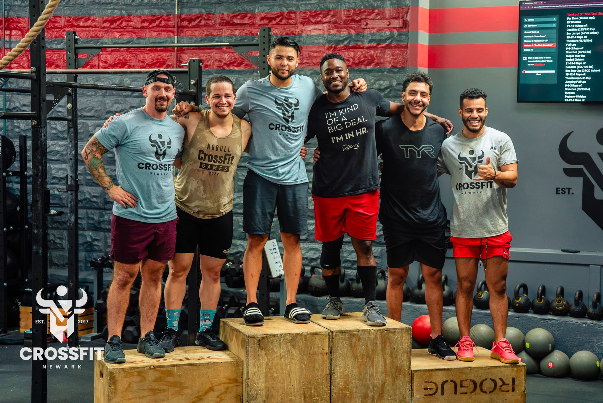 A group of men are posing for a picture in a gym.