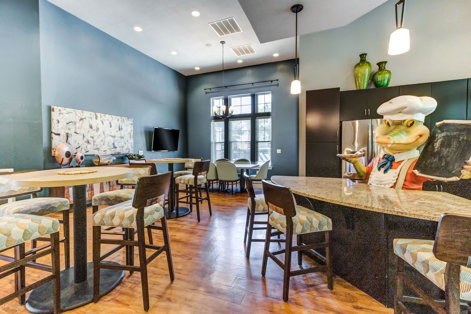 Clubhouse interior with a frog chef statue, tables, and chairs at The Preserve at Essex Farms, offers apartments in Charleston, SC.