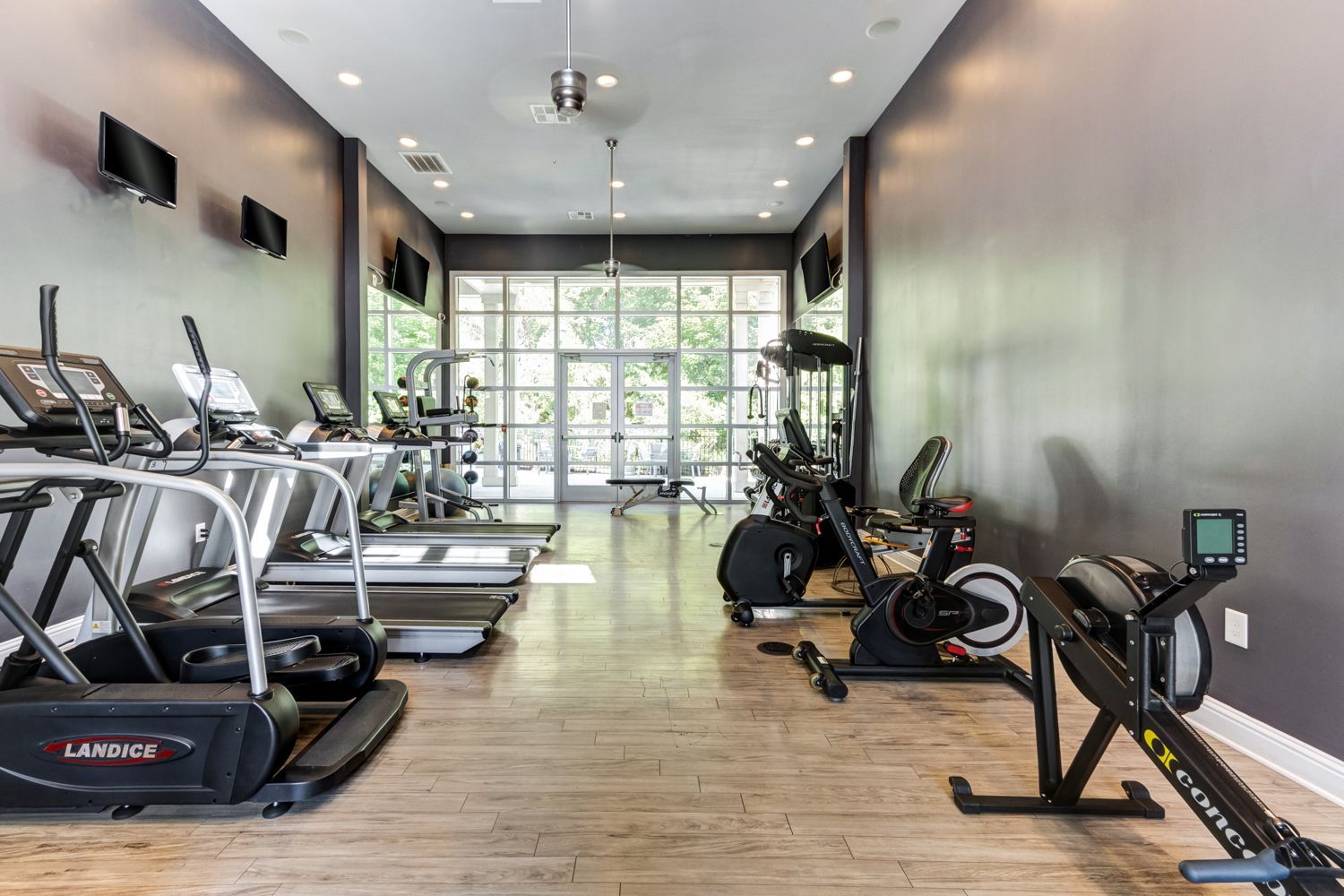 Gym with cardio machines, gray walls, and a large window at The Preserve at Essex Farms, offers 1, 2, and 3 bedroom apartments in West Charleston, SC.