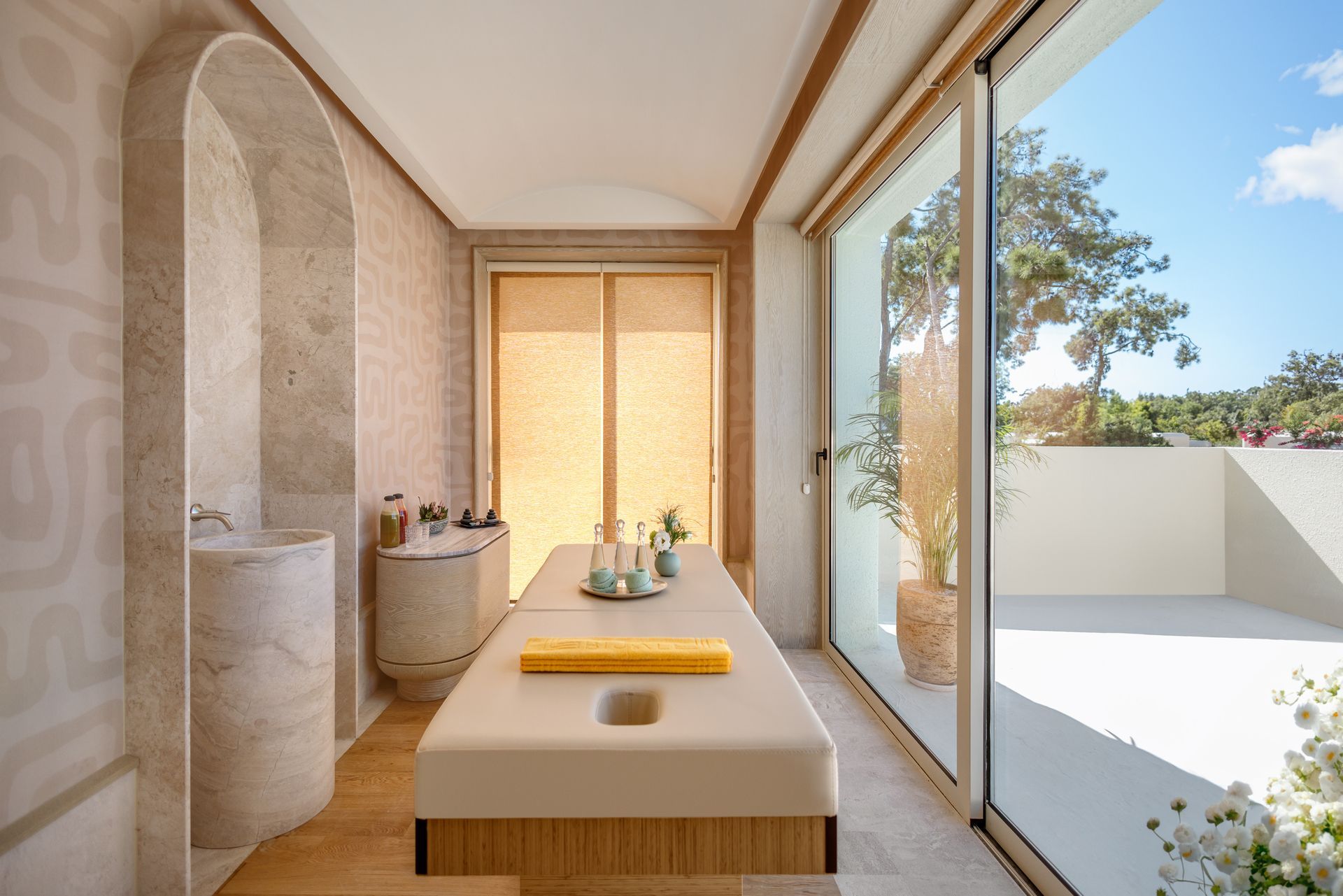 A massage table in a room with a sliding glass door.