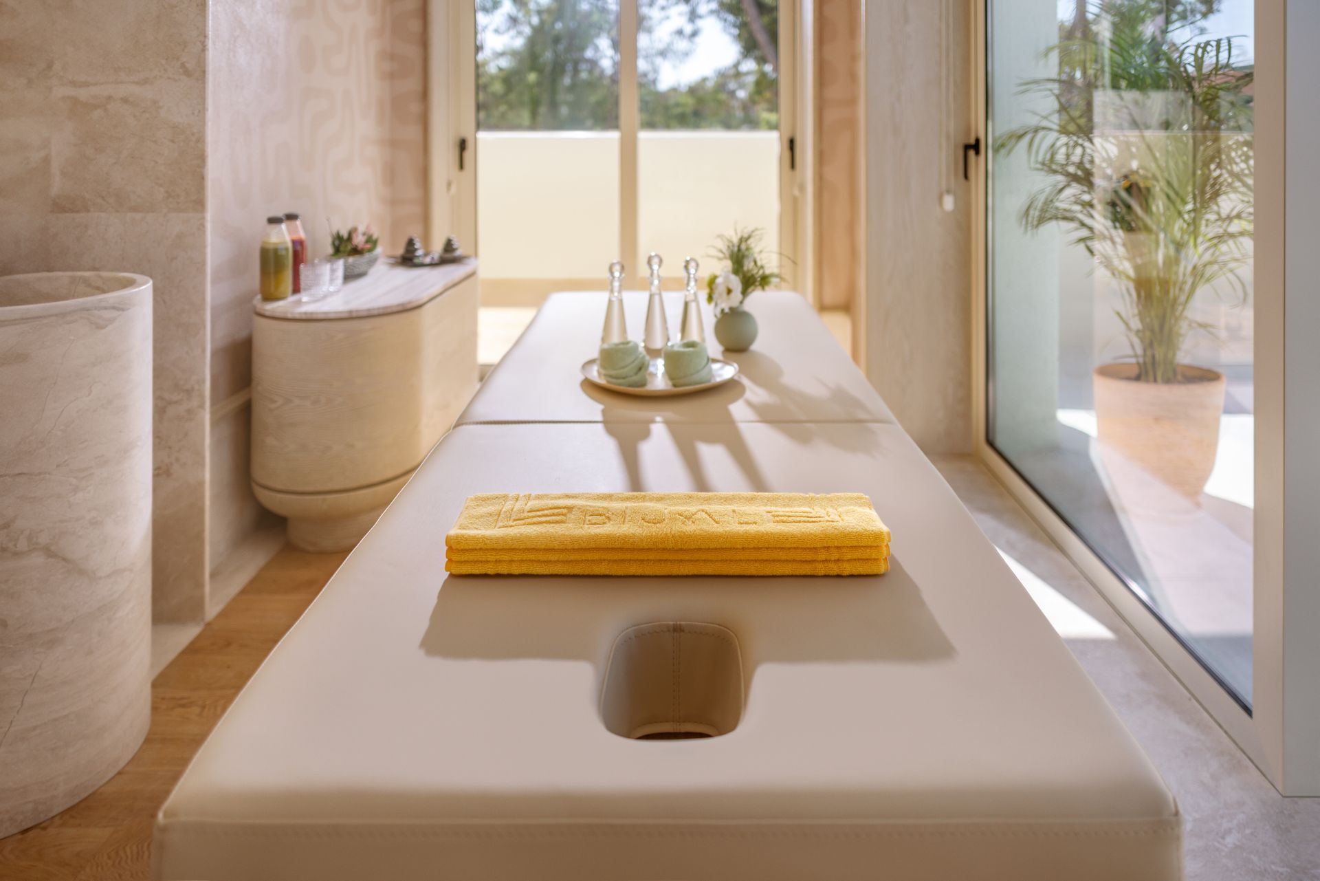 A long white table with a yellow towel on it in a bathroom.