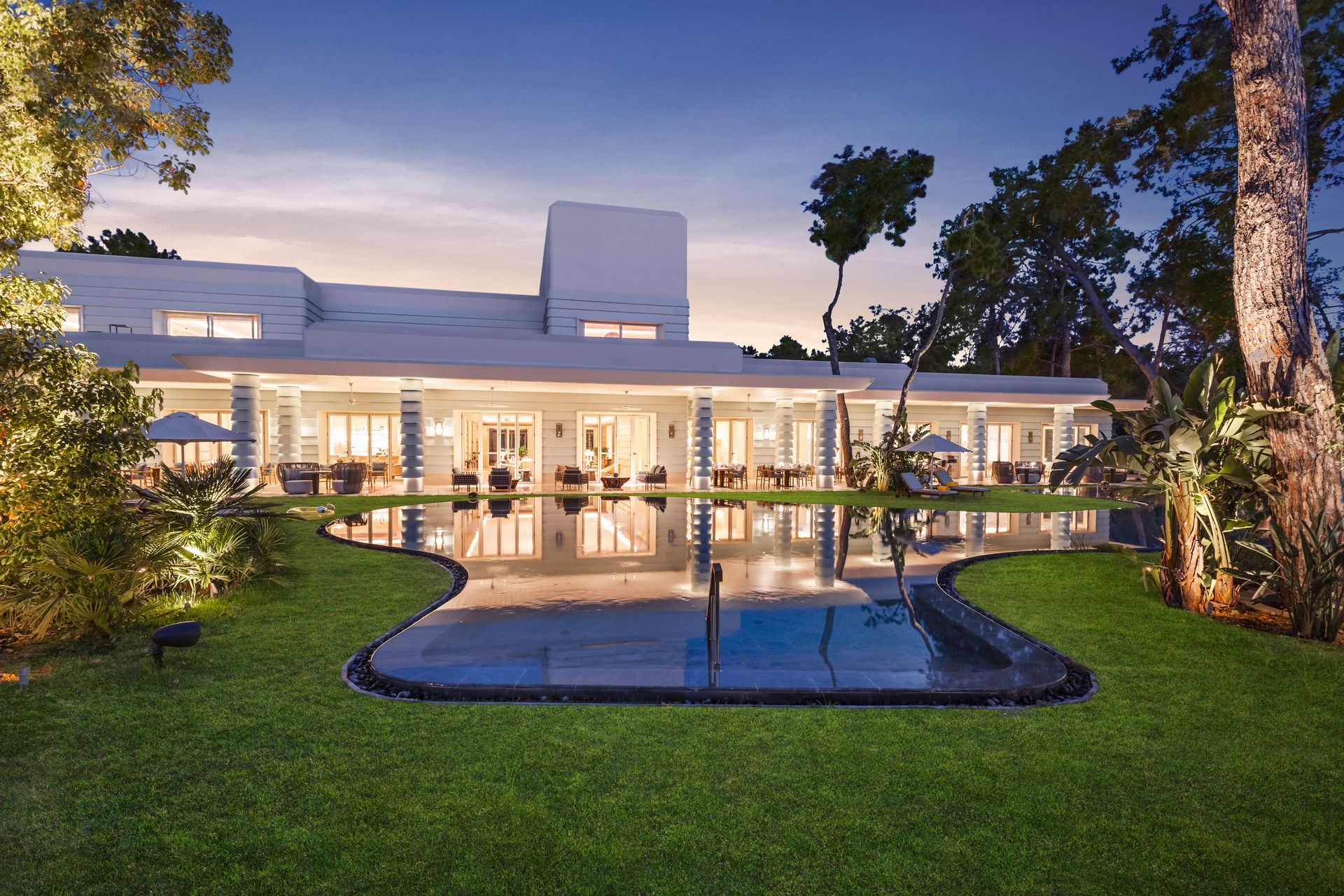 A large white house with a swimming pool in front of it