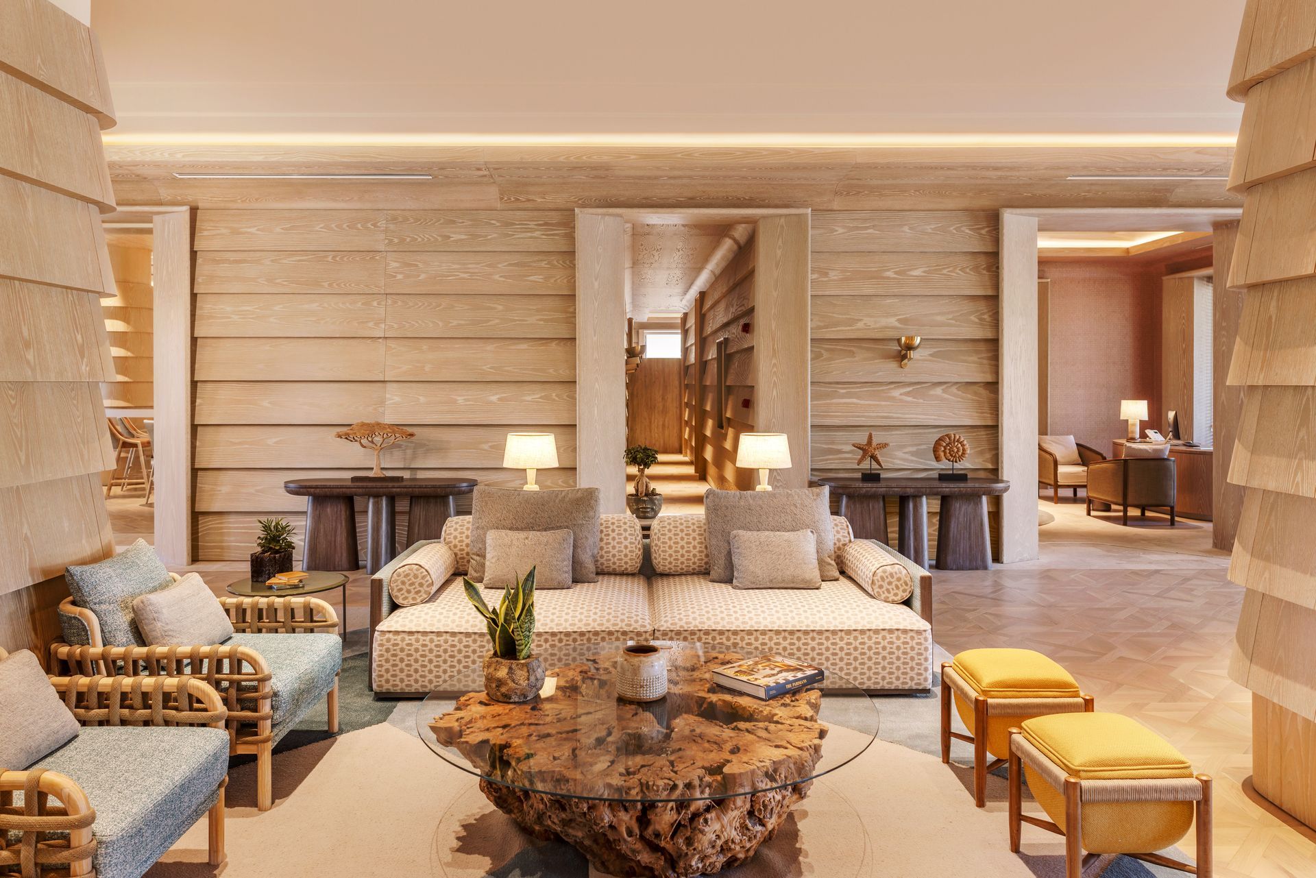 A living room with a couch , chairs , and a wooden table.