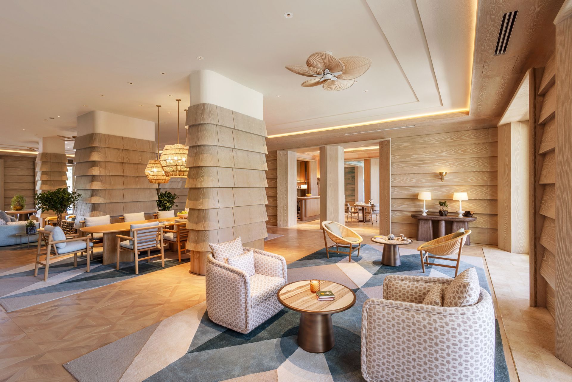 An artist 's impression of a living room with chairs , tables and a ceiling fan.