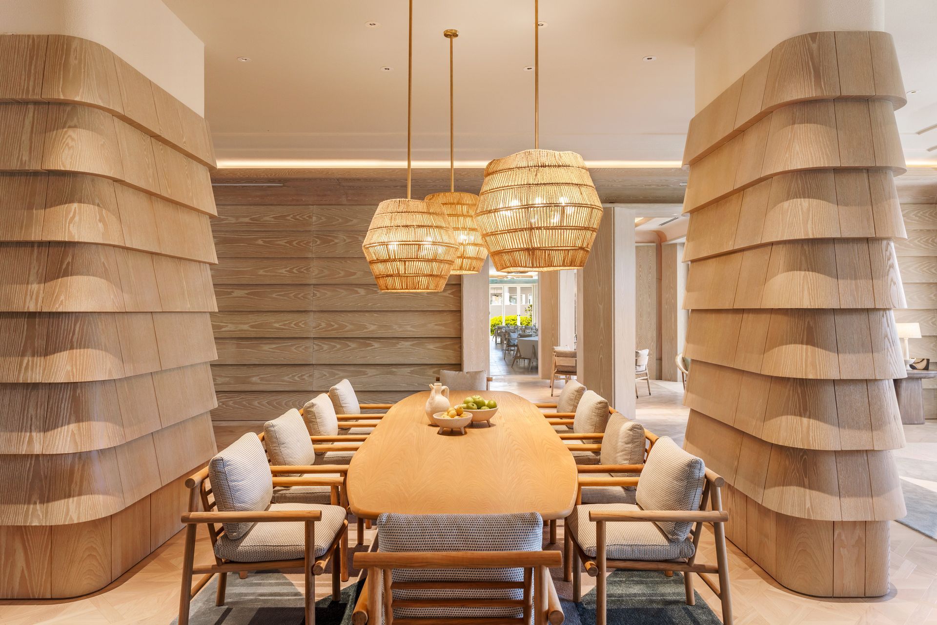 A dining room with a long wooden table and chairs.