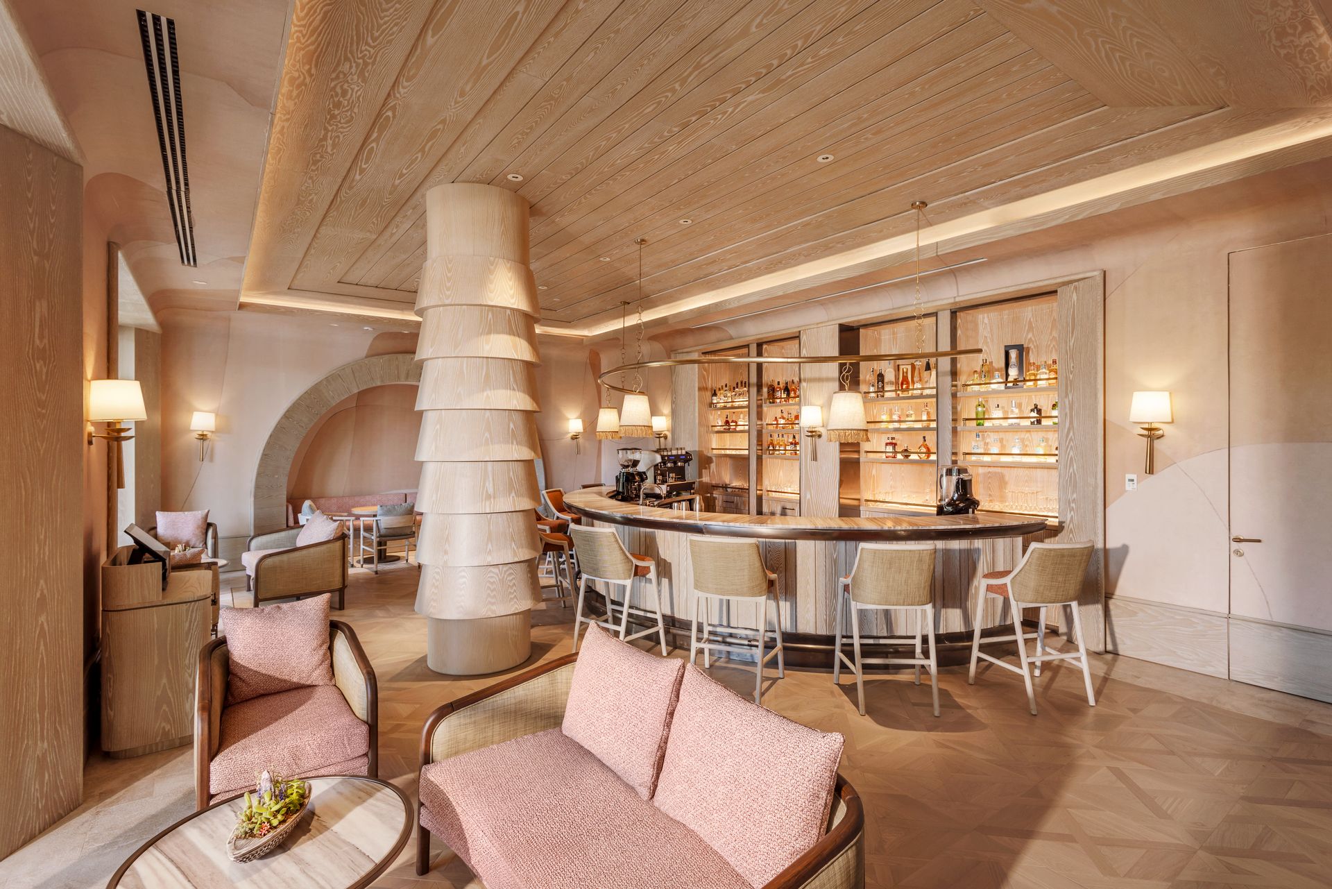 A large room with a couch , chairs , and a bar.