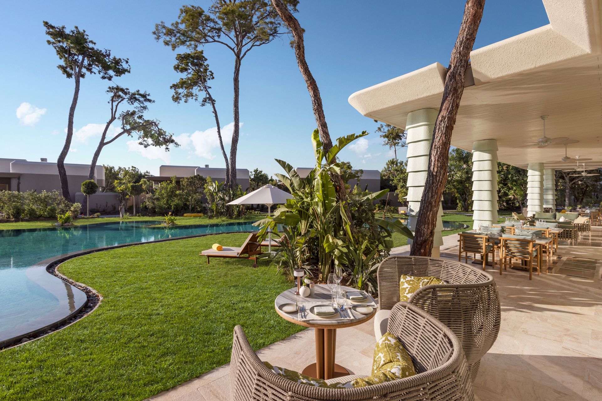 A patio with a table and chairs next to a swimming pool.