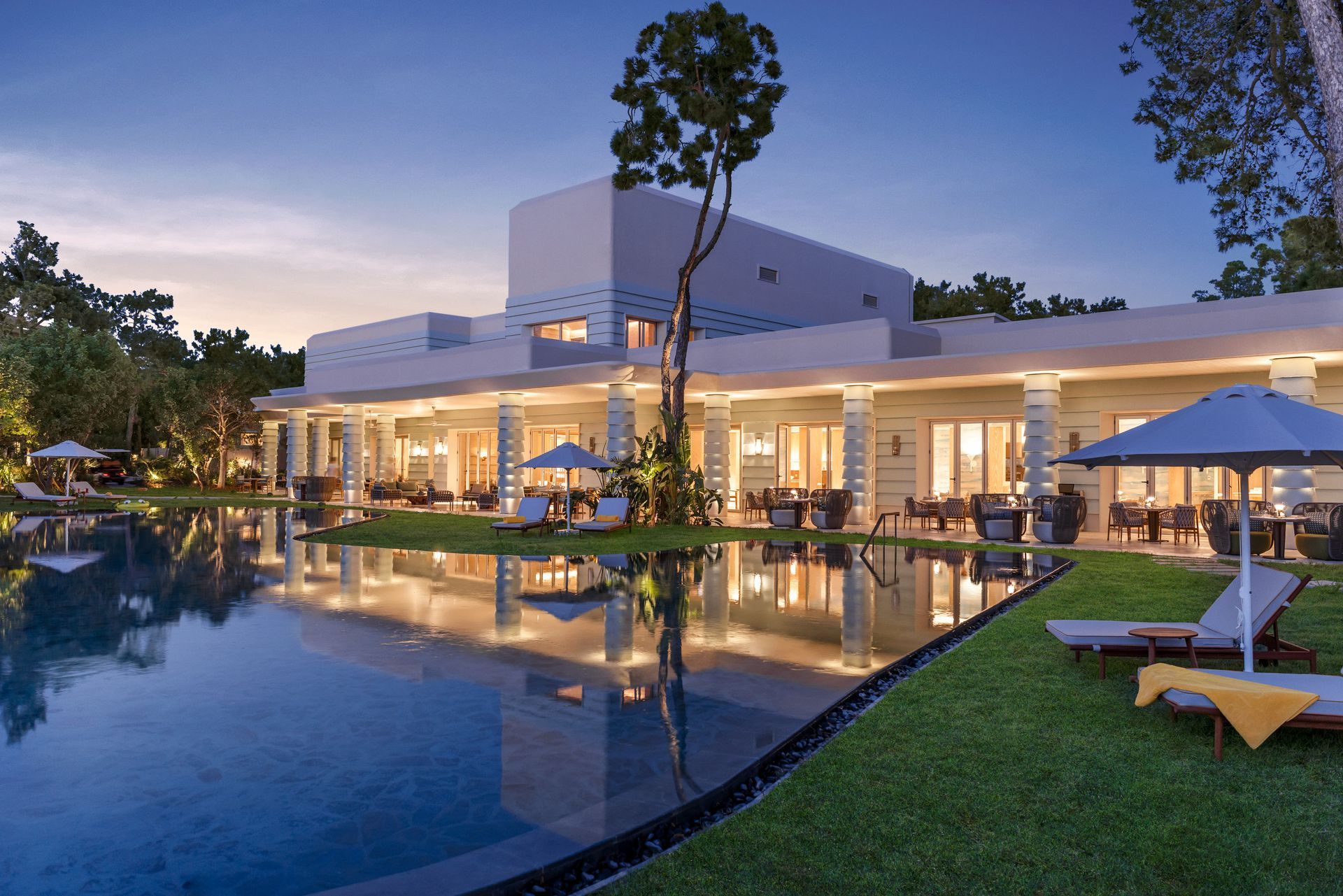 A large white building with a swimming pool in front of it
