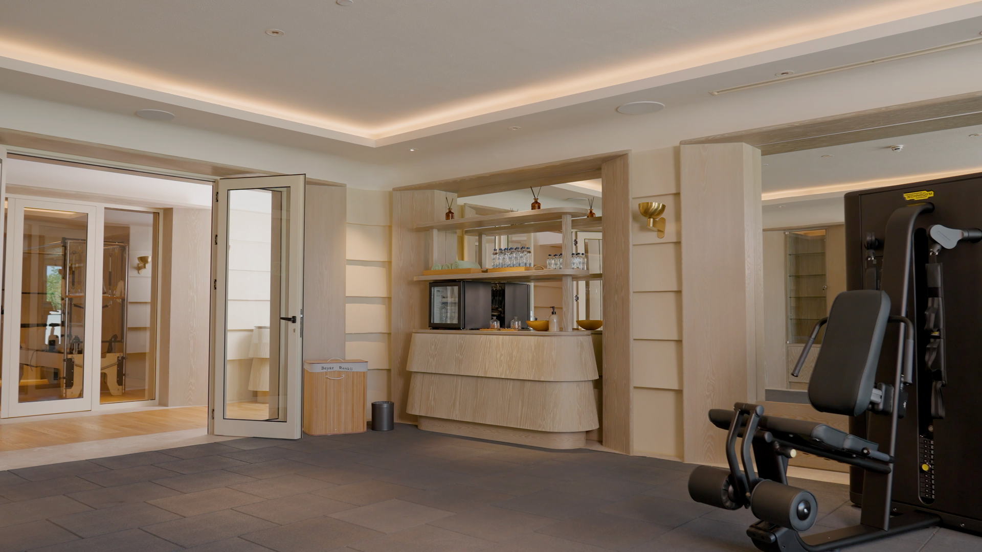 There is a gym in the middle of the room with a treadmill.