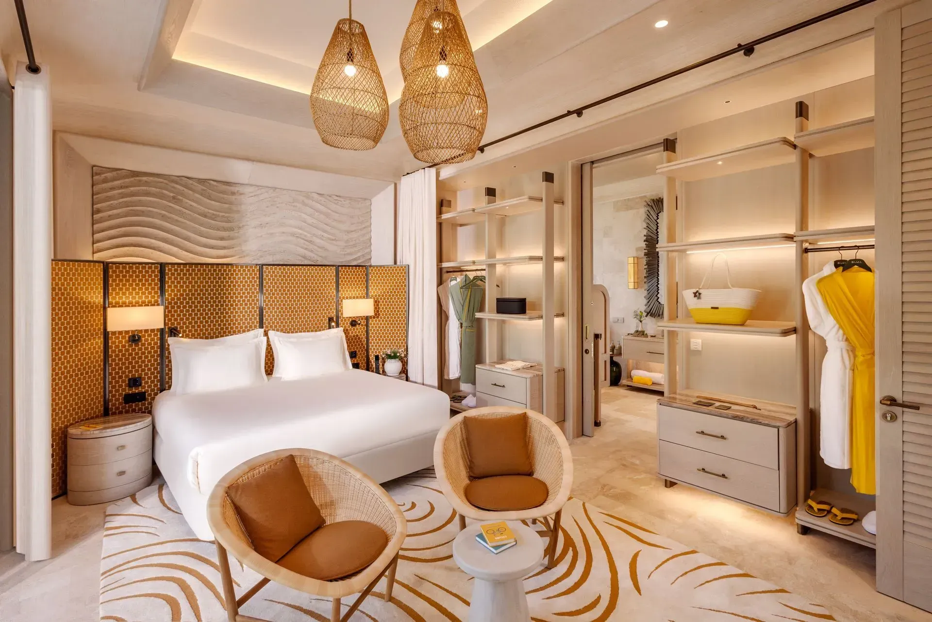 A hotel room with a large bed , chairs , and a walk in closet.