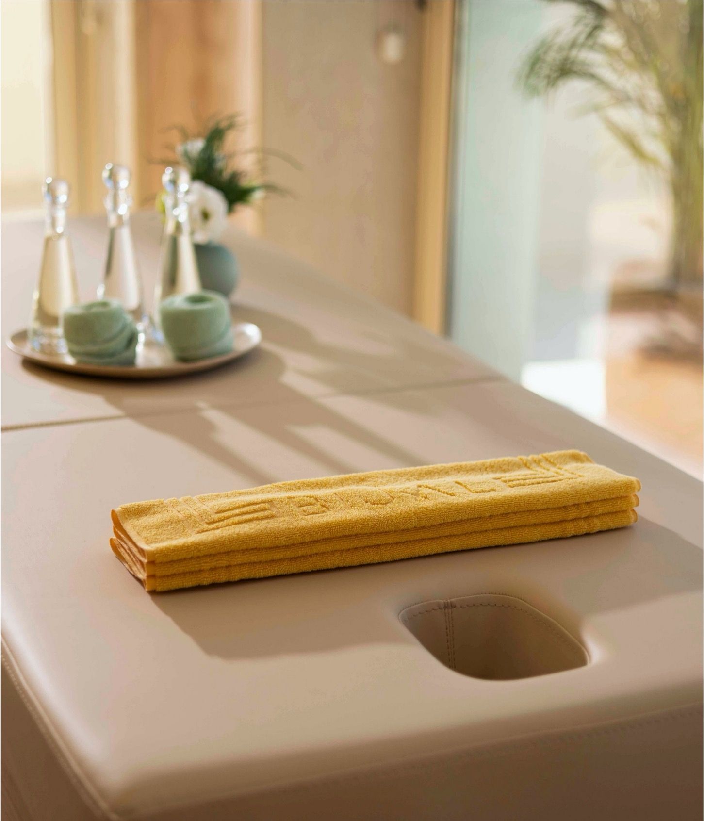 A yellow towel is sitting on a counter next to a sink.