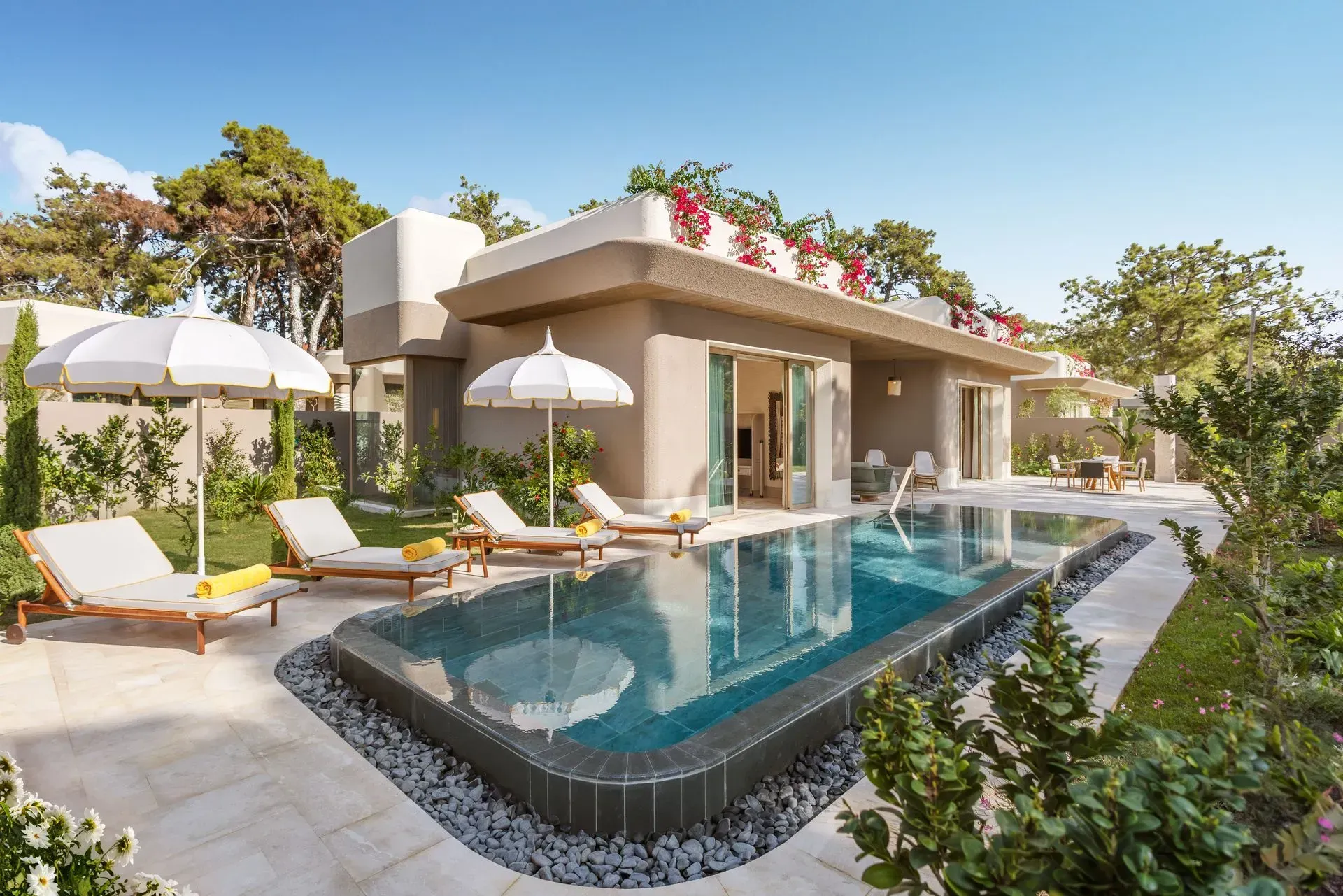 There is a large swimming pool in front of a house.