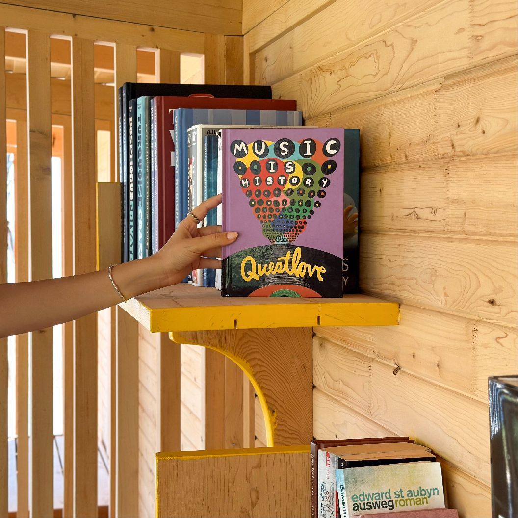 A person is pointing at a book titled music questlove