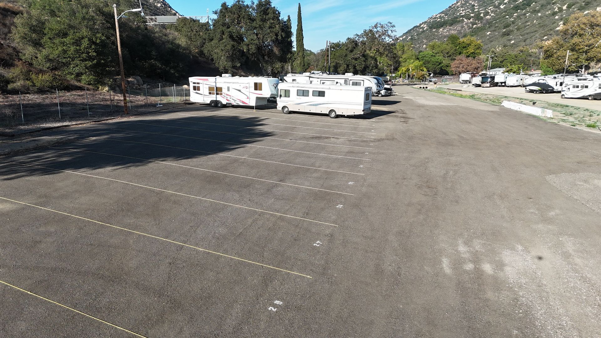 Indoor parking garage with white pillars and walls marked with horizontal stripes, and black and yellow barriers.