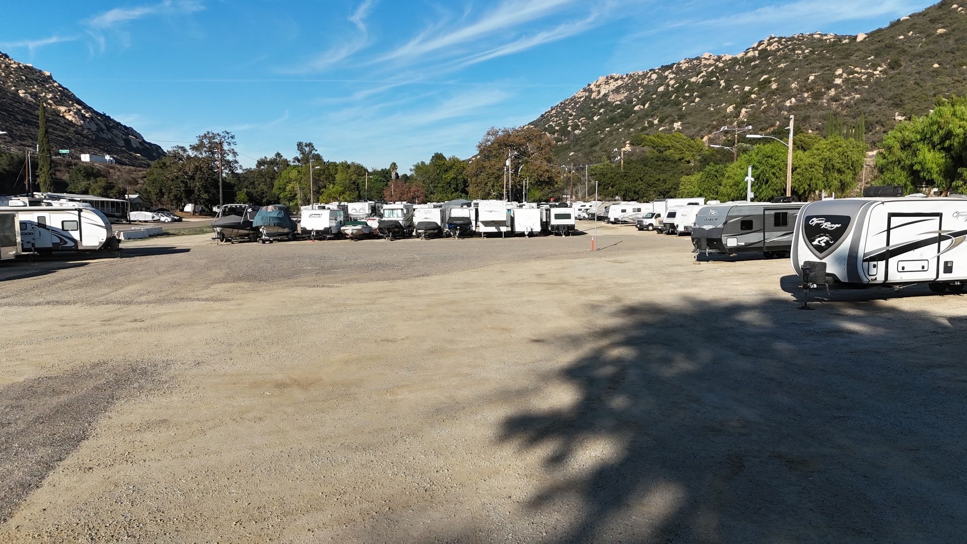 Empty, modern parking garage with gray asphalt, white lines, and striped ceiling.