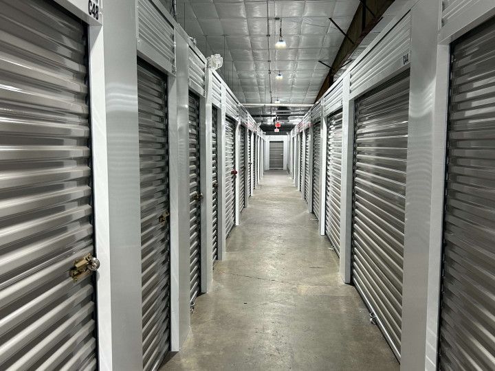 Interior view of a storage unit facility with a long hallway lined with metal unit doors.