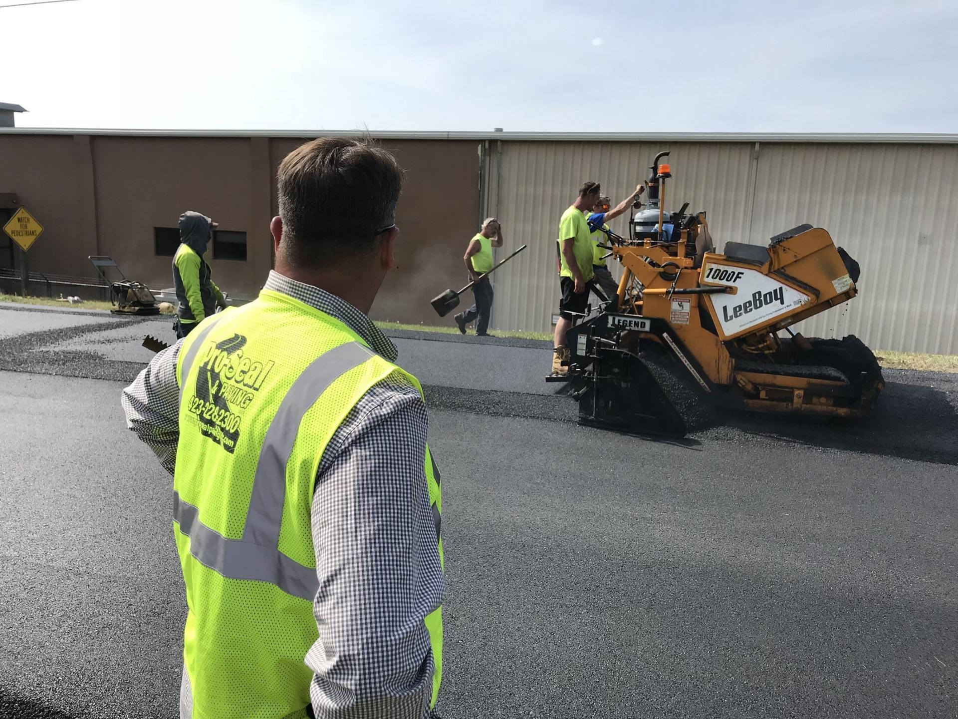 Men Paving Asphalt With Machine — Chatanooga, TN — Pro-Seal & Paving LLC