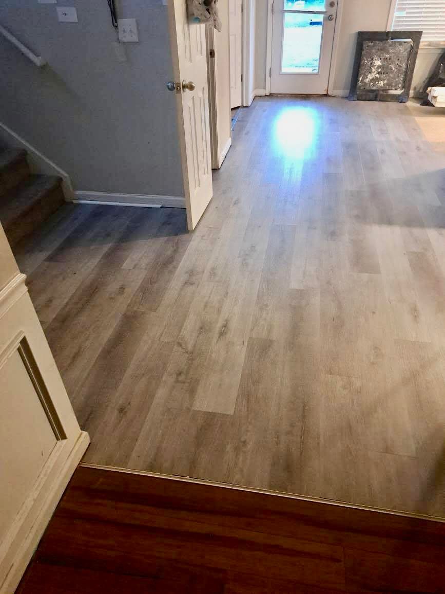 Light gray wood-look flooring extends from bottom to the top of the frame. A doorway is at the end.