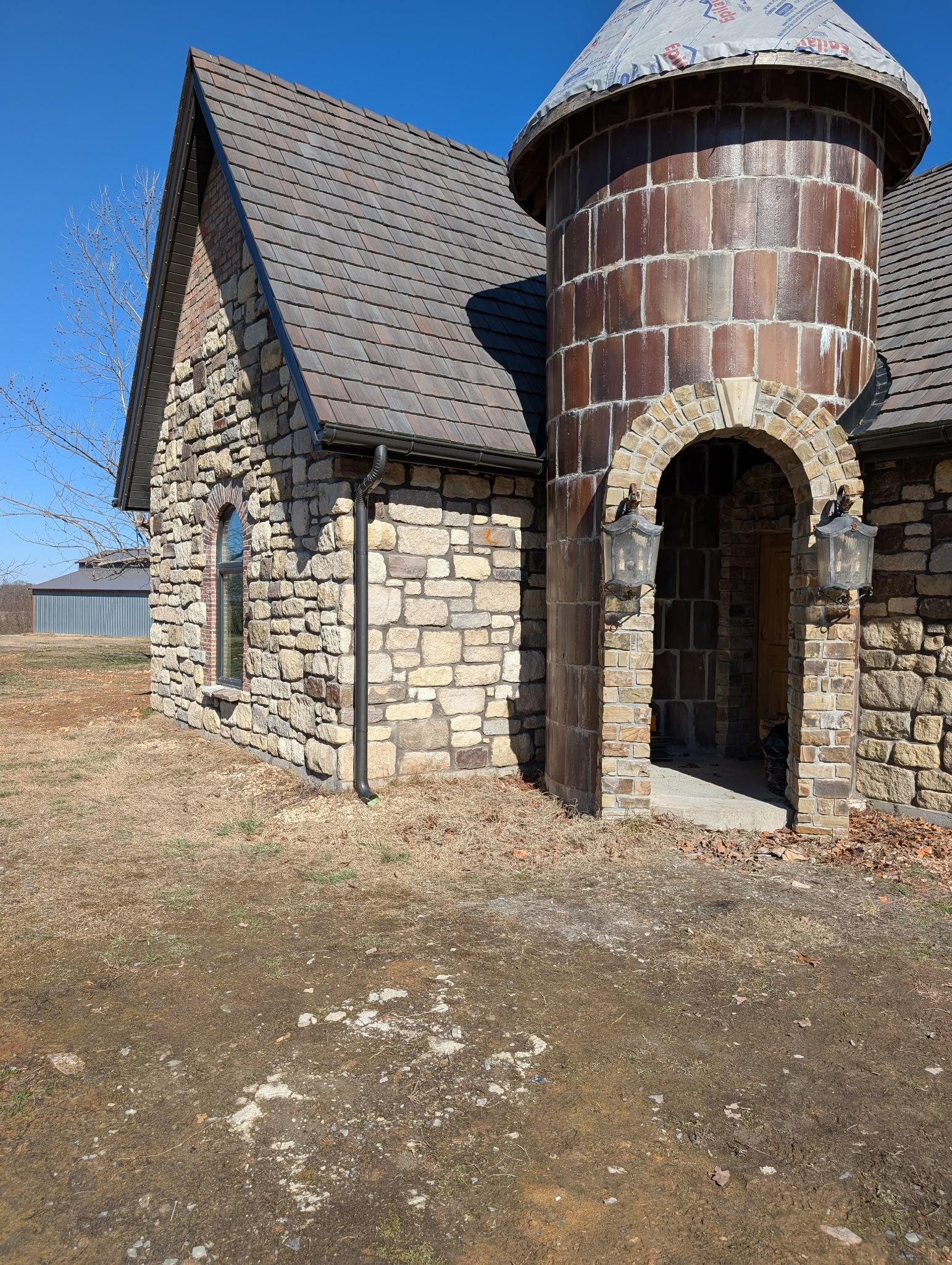 Another view of the home resembling a castle where new gutters were installed, custom made by Hog Trough Seamless Gutters