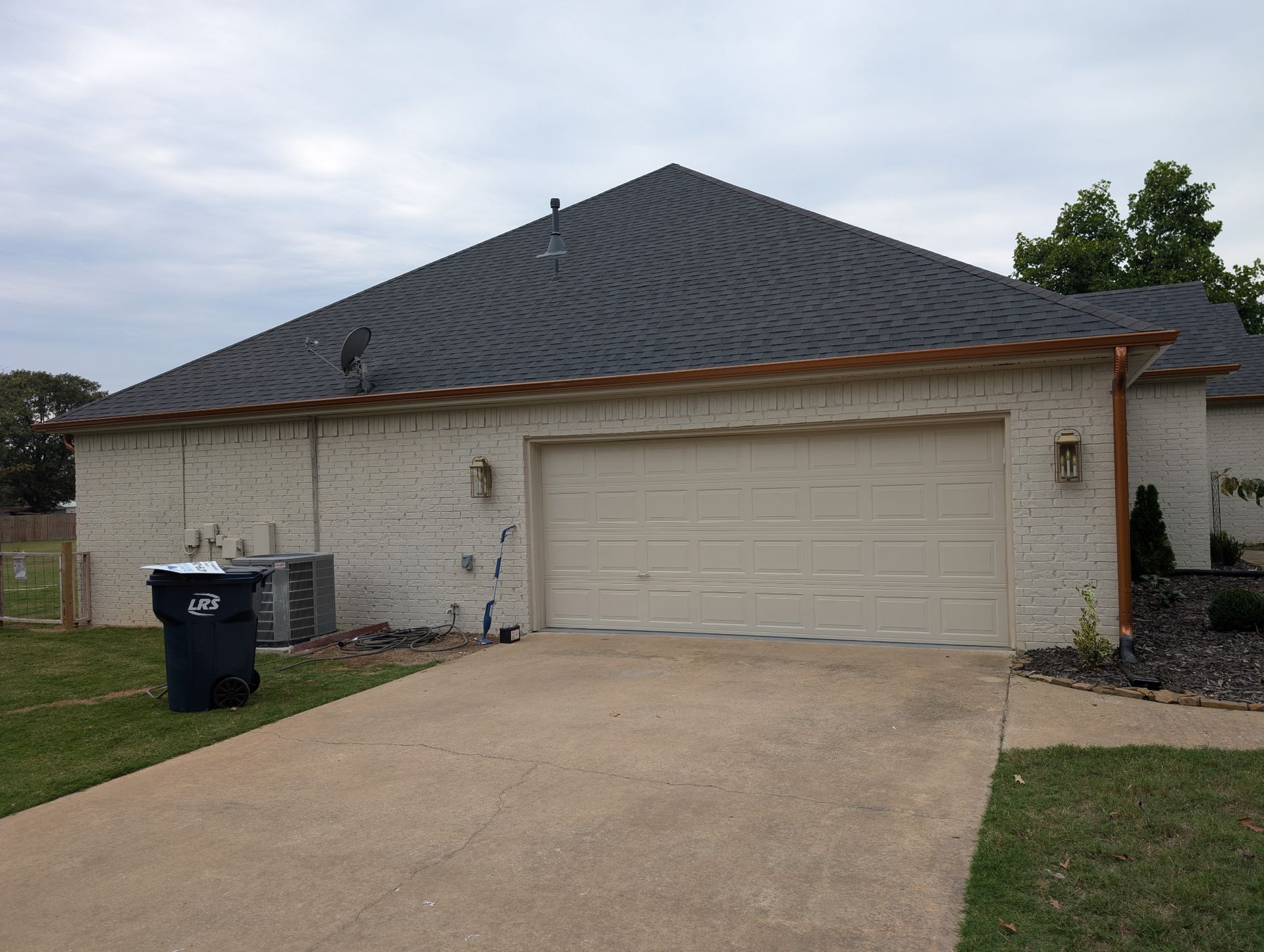 Driveway and garage door of a home where new gutters were installed