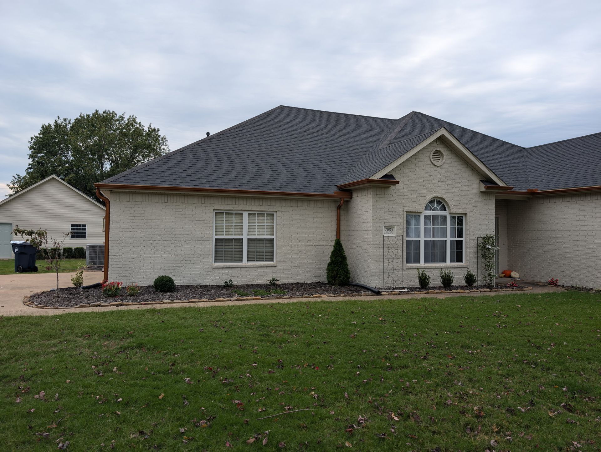 A view of a home with gutters and drainage, custom made by Hog Trough Seamless Gutters