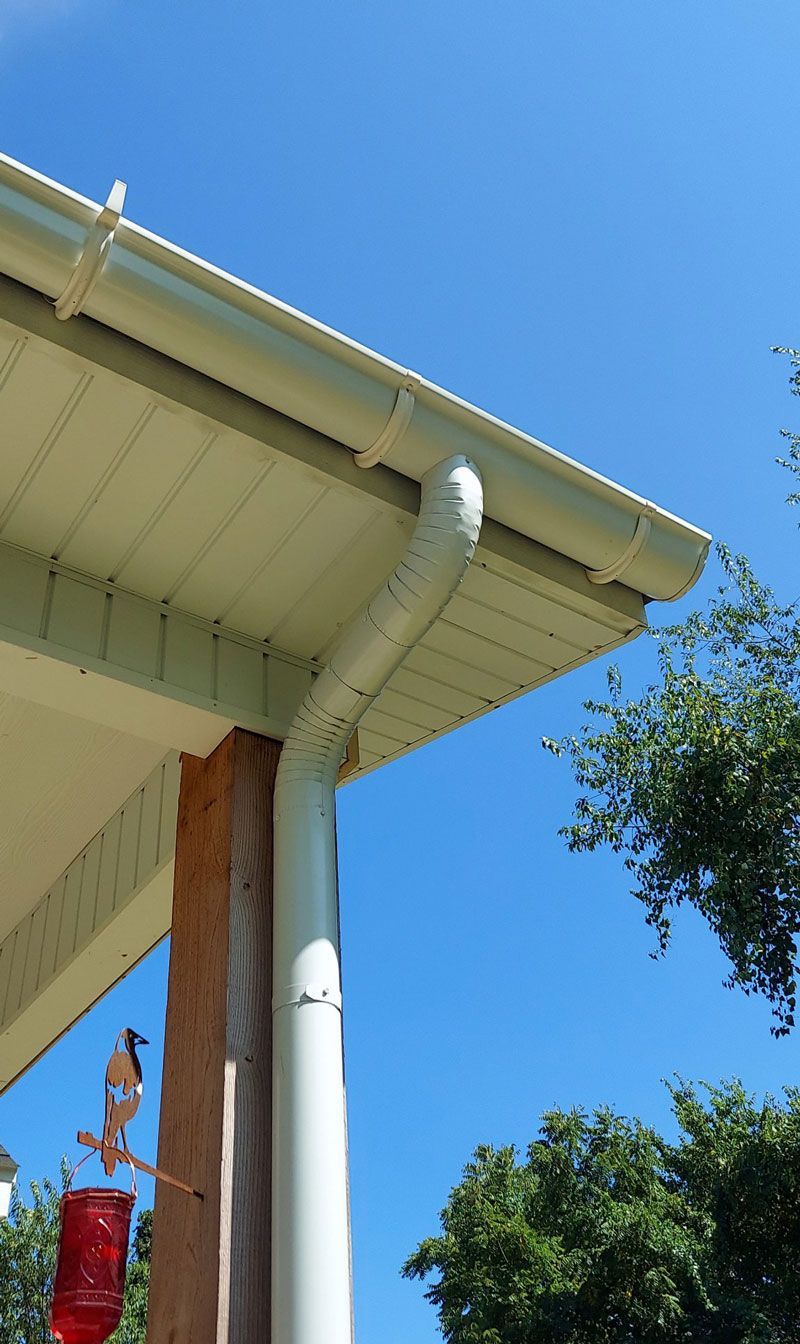 A bird feeder is on the porch of a house.
