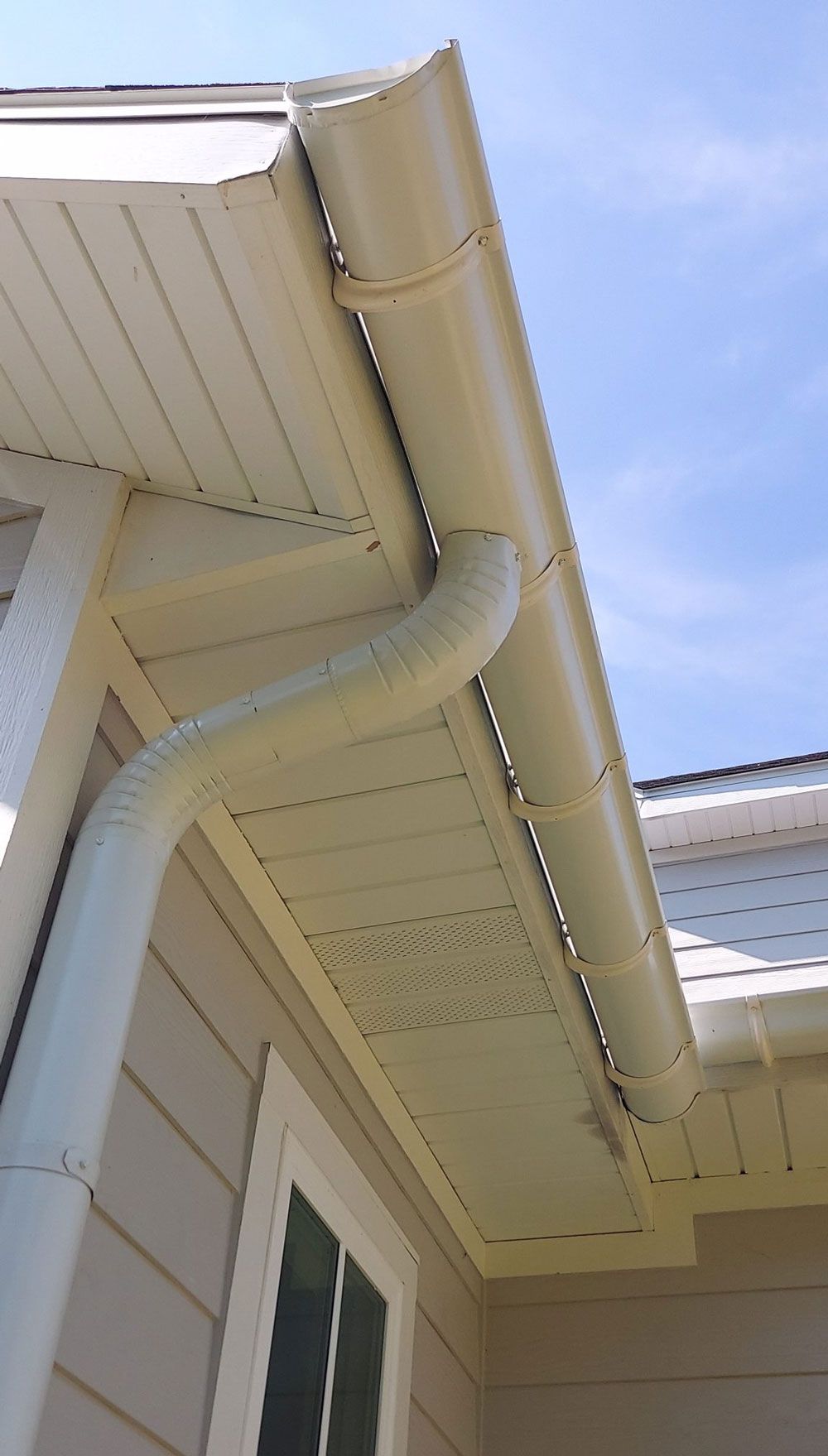 A close up of a gutter on the side of a house.