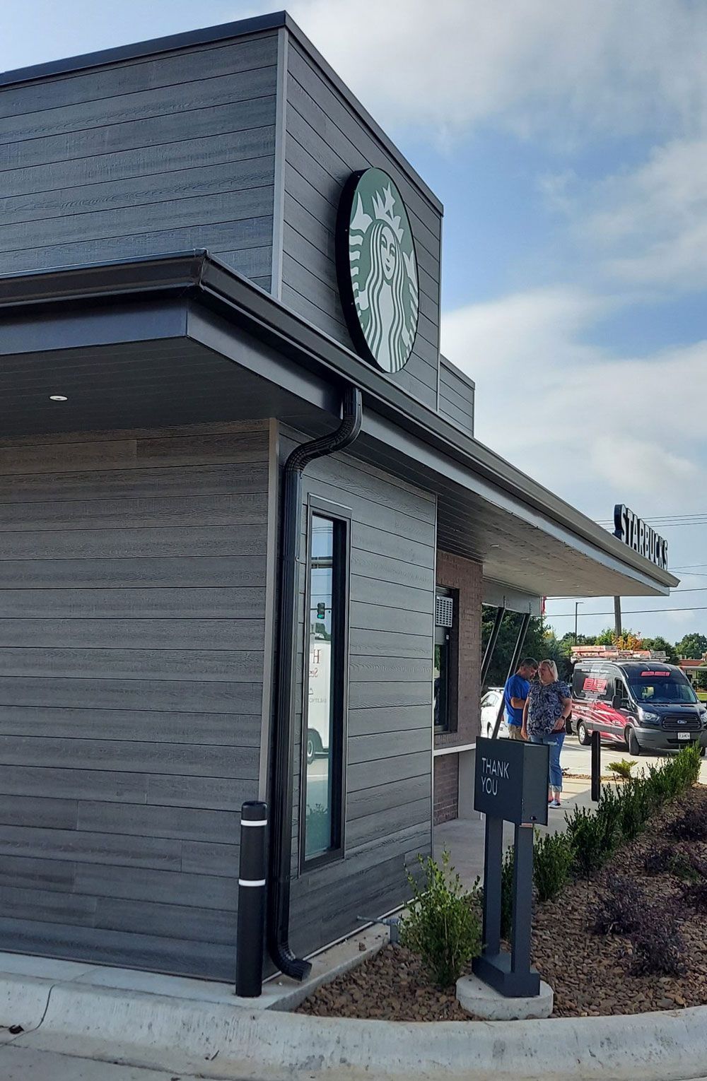 A starbucks coffee shop with a clock on the side of it.