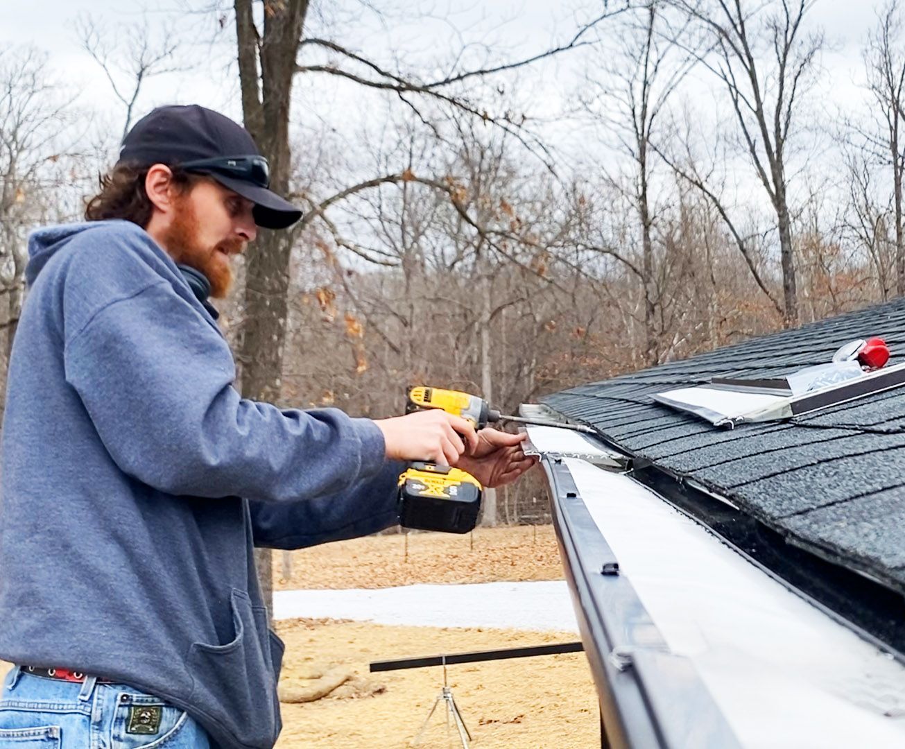 Hog Trough employee drilling in a gutter 