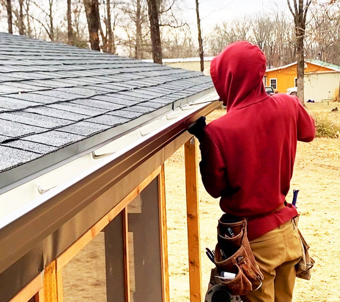 Hog Trough employee drilling in a gutter 
