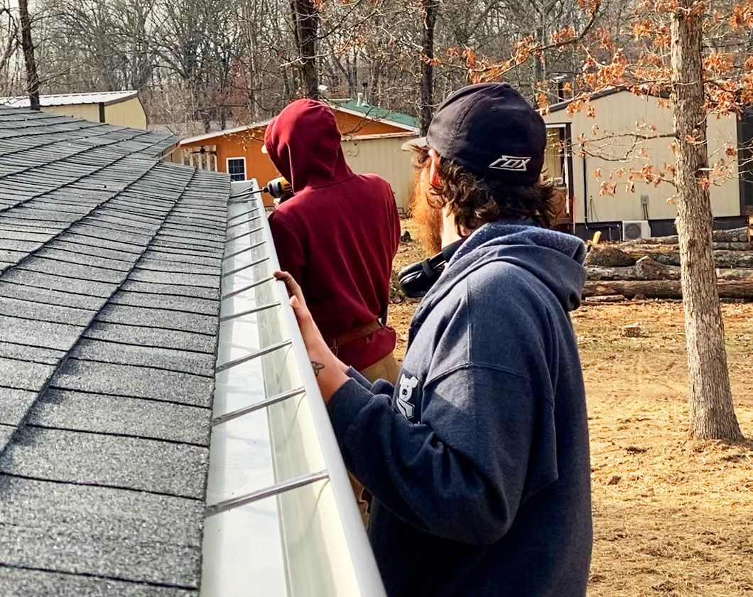 Two Hog Trough employee's holding a gutter 