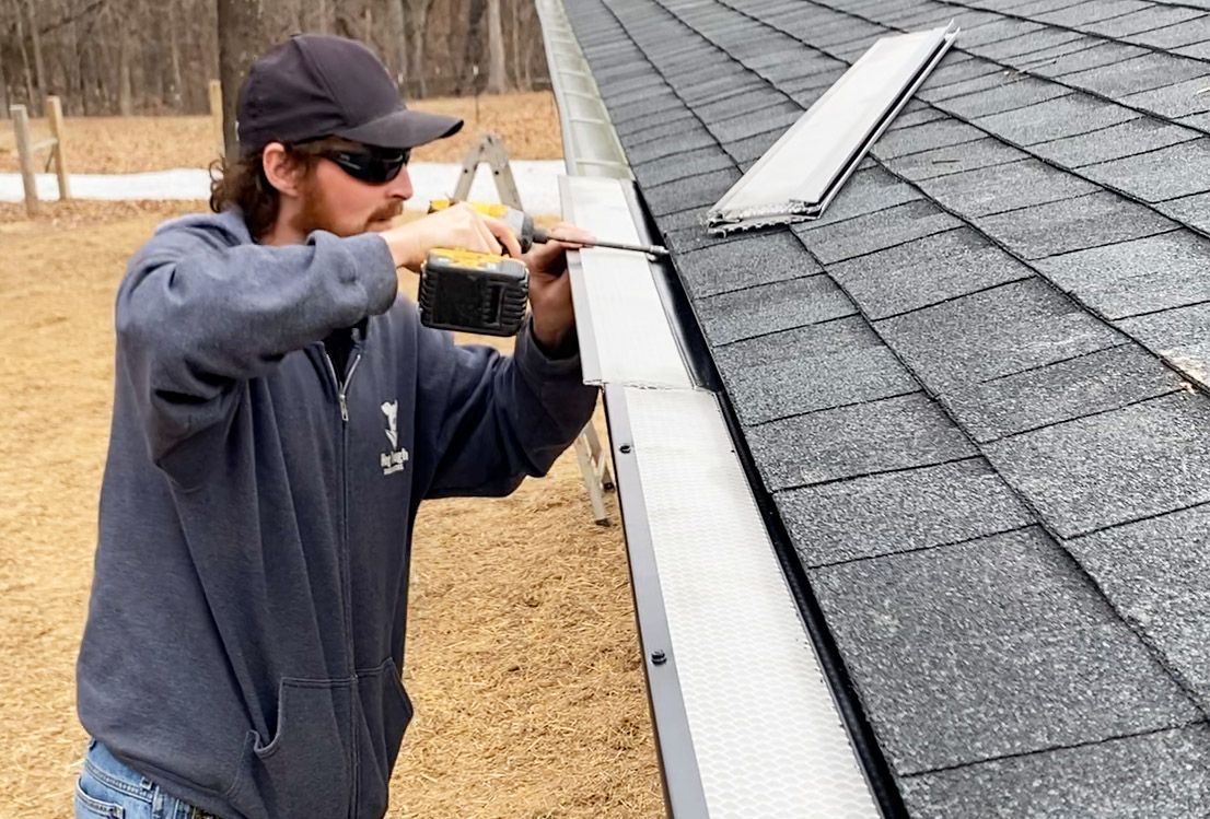 Hog trough employee drilling a top cover for a gutter 