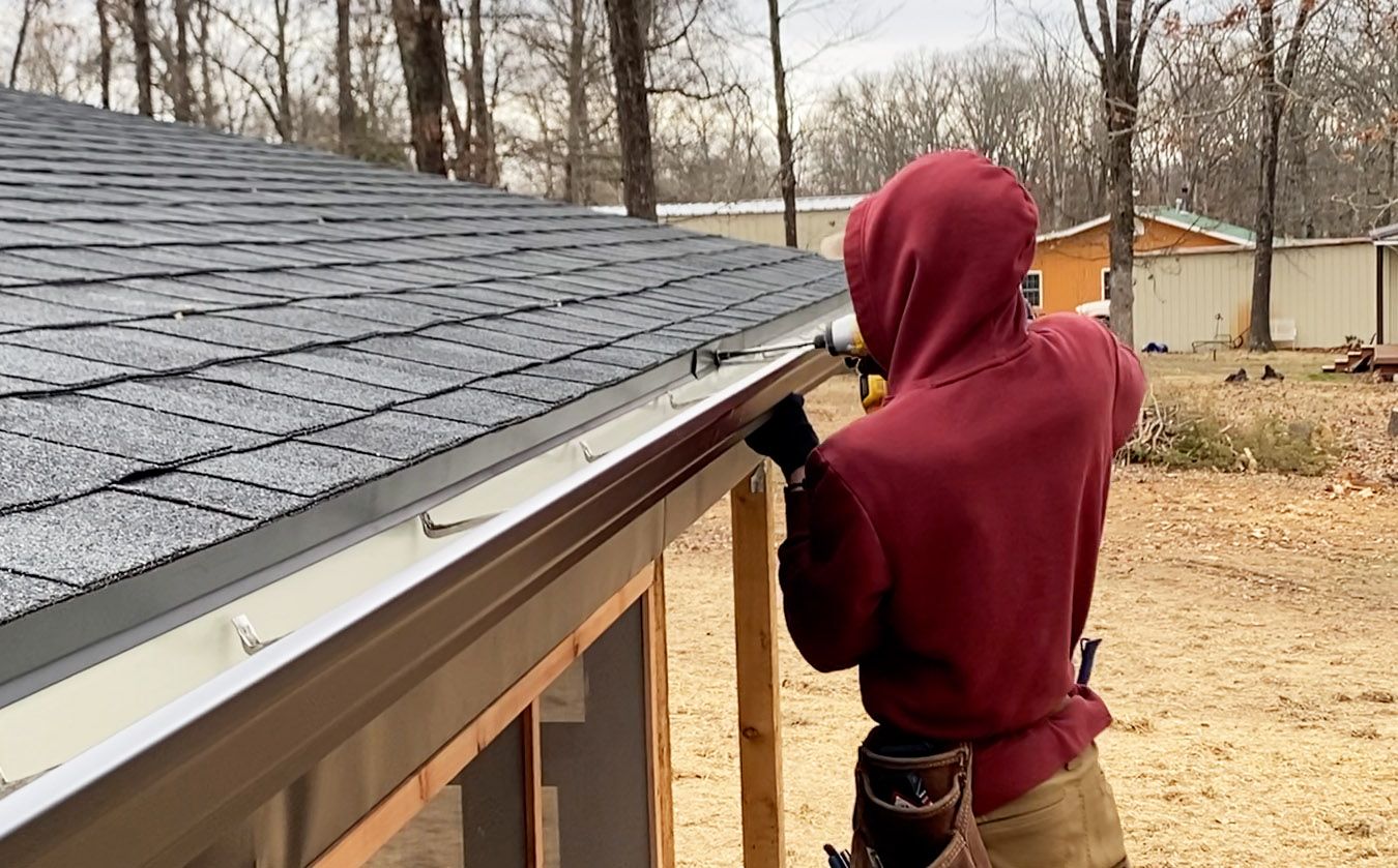 Hog Trough employee putting a gutter in place 